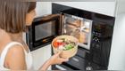 chica mete verduras al microondas