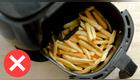 freidora de aire con papas fritas y signo de error