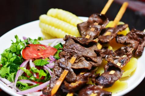 Los anticuchos se sirven con papa, choclo, cremas de ajíes y ensalada.   