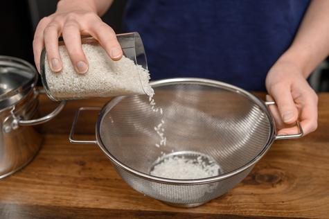 Lavar el arroz para eliminar el polvo y el almidón.   