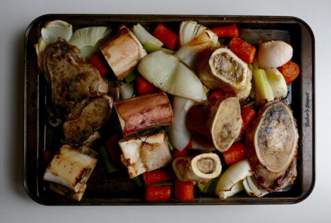 Huesos y verduras doradas en el horno.   