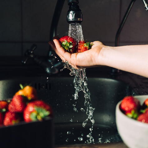 El agua corriente es el primer paso en el proceso de lavado y desinfección de las fresas.    