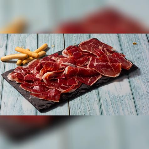 El jamón ibérico, cortado a mano, es el emblema de la gastronomía madrileña y una tradición que se celebra en cada barra.