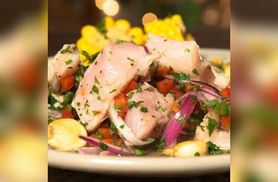 Ceviche boliviano de surubí: una fresca preparación de pescado de río marinado en limón, acompañado de yuca cocida y plátano frito.   