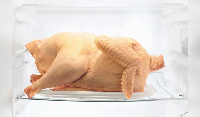 En la parte baja y en bandeja, para evitar que sus jugos entren en contacto con alimentos frescos.   