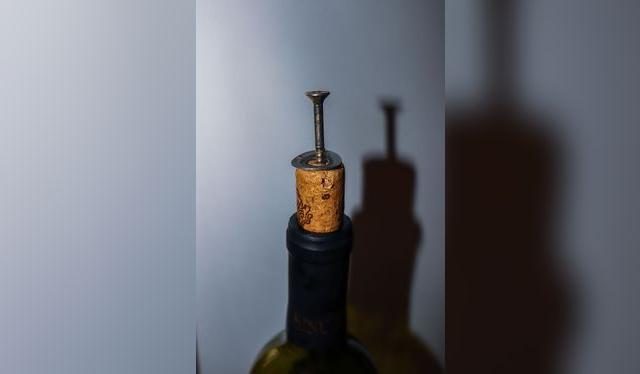 Una vez que el tornillo atravesó el corcho, puedes jalarlo con un alicate o martillo.   