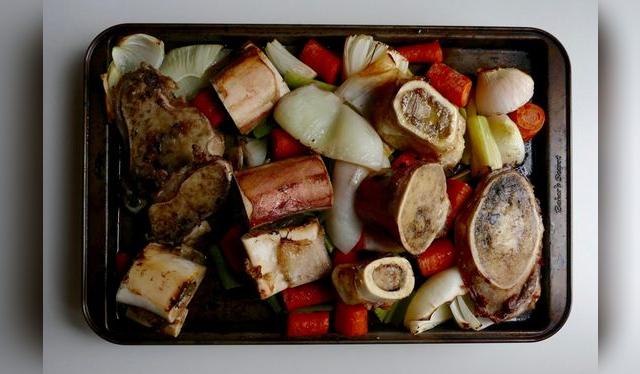 Huesos y verduras doradas en el horno.   