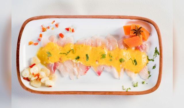 Tiradito con salsa de ají amarillo, un clásico moderno de la cocina marina peruana.   