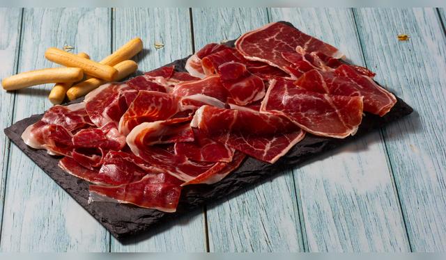 El jamón ibérico, cortado a mano, es el emblema de la gastronomía madrileña y una tradición que se celebra en cada barra.