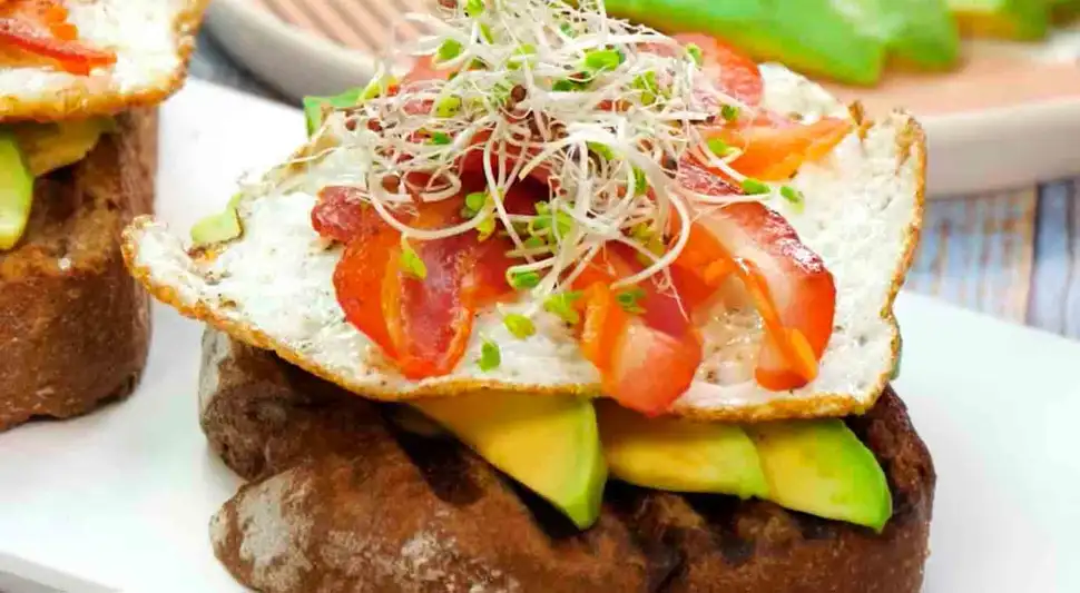 Tostones con palta, huevo y tocino
