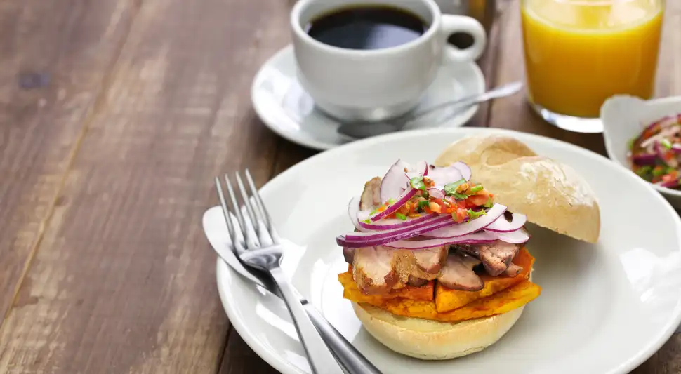 Descubre el delicioso ritual del pan con chicharrón, el sándwich preferido de los peruanos, que combina carne jugosa, piel crujiente y sabores únicos. Este típico desayuno nacional es un motivo de orgullo. Foto: Envato